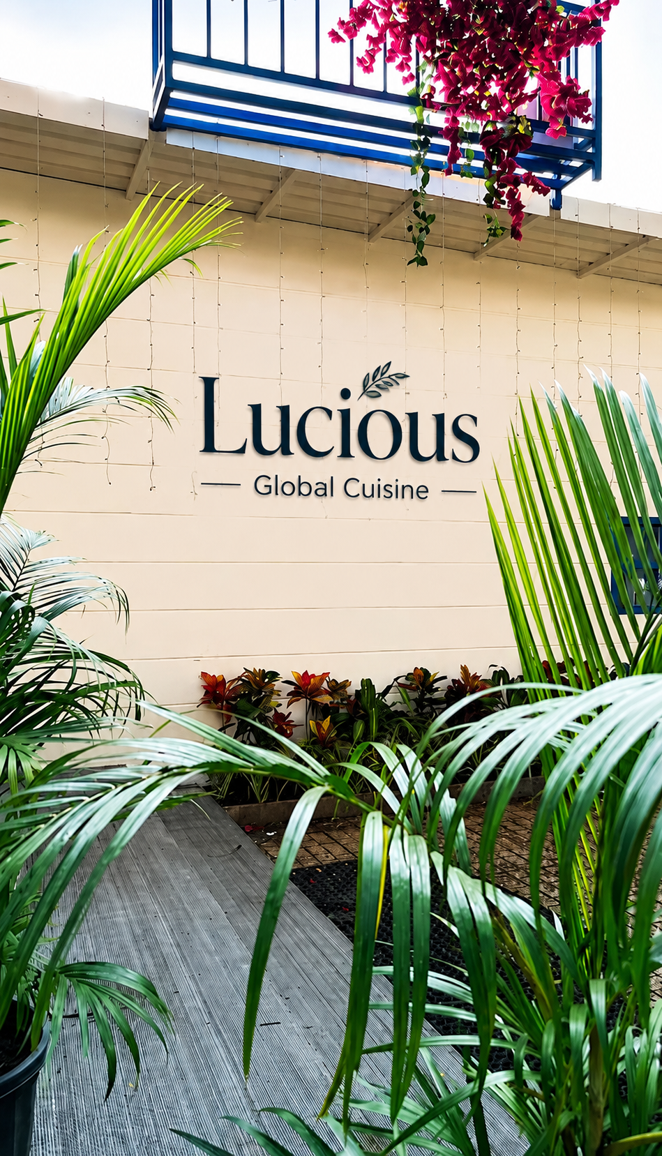 Lucious Global Cuisine restaurant entrance with tropical greenery